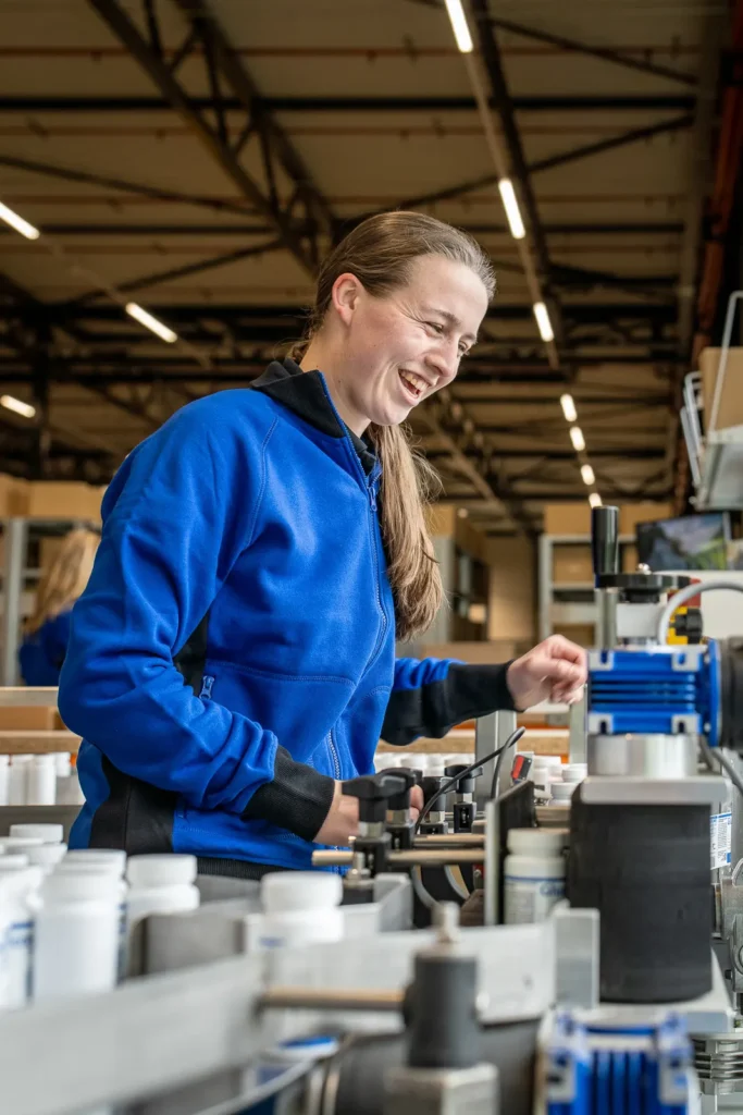Vrolijke LSE medewerker bij etiketteermachine